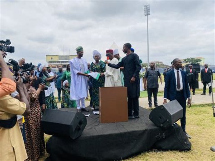 Who designed the Nigerian coat of arms? Where was Taiwo Akinkunmi born?